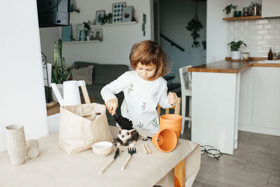 Young woman with cat sitting on table at home