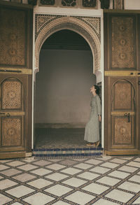 Woman leaning against a moroccan style door, marrakech