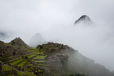 Scenic view of mountains against sky during foggy weather