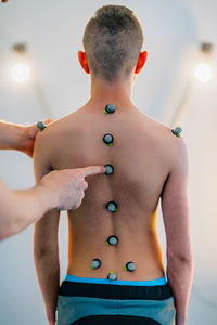 Cropped hands of man examining male patient in health club