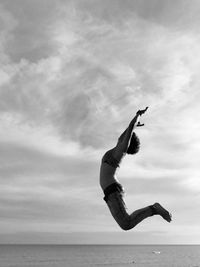 Side view of man surfing in sea against sky