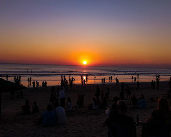 Group of people on beach during sunset