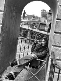 Portrait of woman sitting on railing