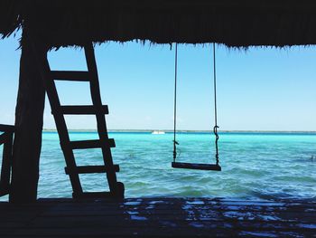 Swing hanging against sea