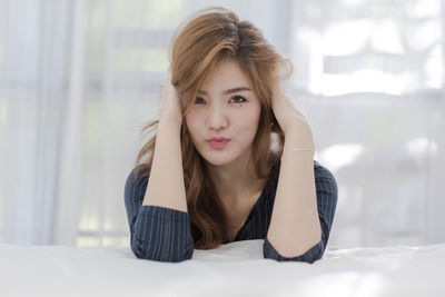 Portrait of beautiful young woman with hands in hair