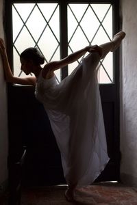 Ballet dancer dancing against closed door