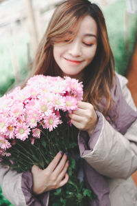 Beautiful woman holding pink flowering plants