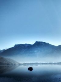 Scenic view of lake and mountains against clear sky