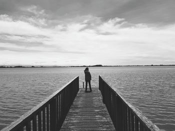 Rear view of man standing on pier