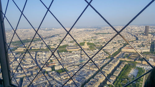 View of cityscape seen through chainlink fence