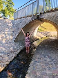 Full length of woman standing against wall