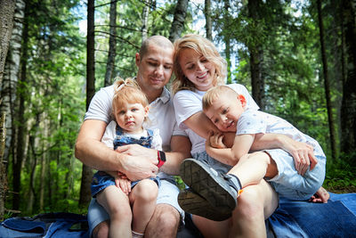 Portrait of family sitting in forest