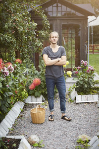 Portrait of male gardener standing arms crossed in yard