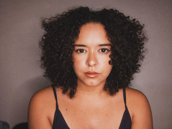 Portrait of beautiful woman against wall