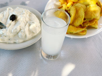 Close-up of greek food on table. traditional local ouzo glass over fried zucchini and tzatziki 