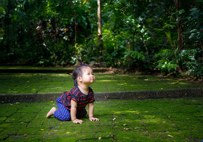 Full length of cute girl kneeling in park
