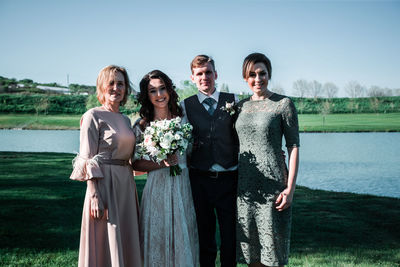 Portrait of friends standing at park against sky