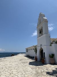 Building by sea against blue sky