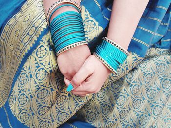 Midsection of woman in blue sari and bangles