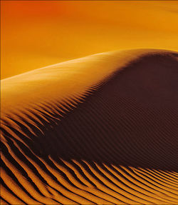 Scenic view of desert against orange sky