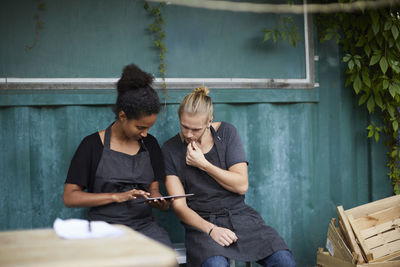 Male and female gardeners with digital tablet in yard
