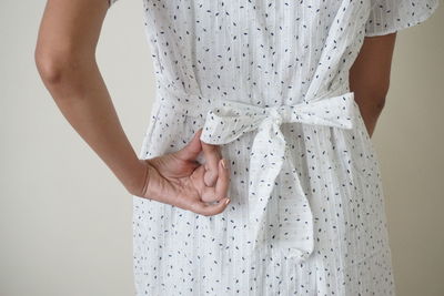 Midsection of woman standing against wall