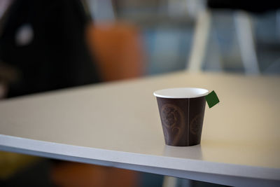 Tea in disposable cup on table