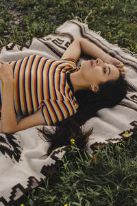 Young woman relaxing on picnic blanket