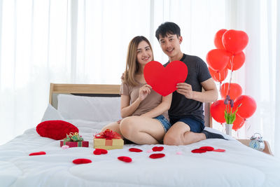 Couple kissing with heart shape on bed