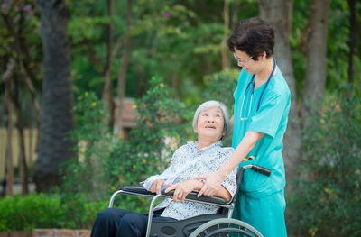 Patient looking at nurse against trees