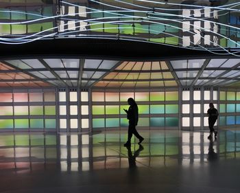 Silhouette people walking in corridor of building