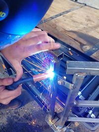 Low angle view of hand holding illuminated factory