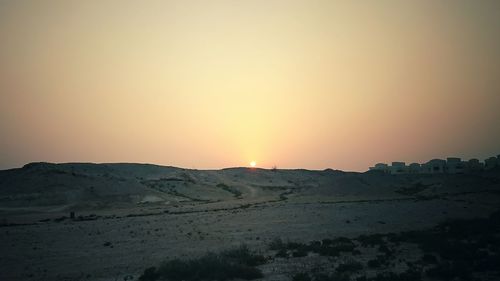 Scenic view of landscape against clear sky during sunset