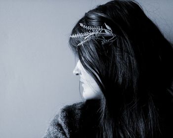 Close-up of woman looking away against white background