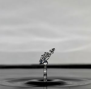 Close-up of drop falling on glass