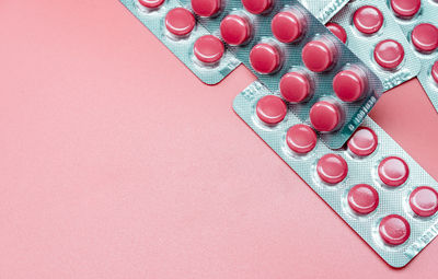 High angle view of medicines on pink background