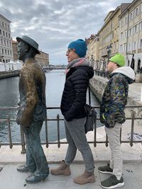 Rear view of man and woman statue against city