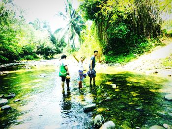 Full length rear view of girl standing in stream