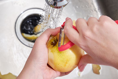 Cropped image of hand holding fruit at home