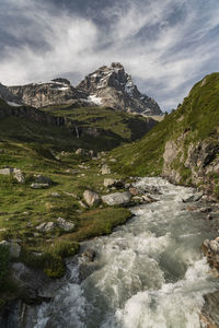 Scenic view of river and mountains against sky