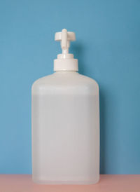 Close-up of white bottle against blue background