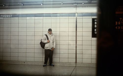 Full length of a young woman standing on tiled floor