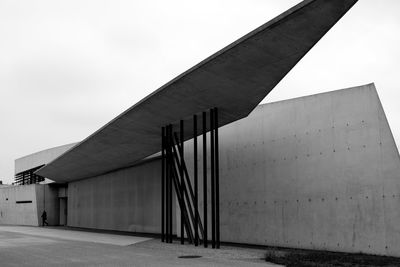 Metallic structure by building against sky