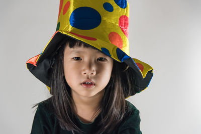 Portrait of happy girl standing against white background