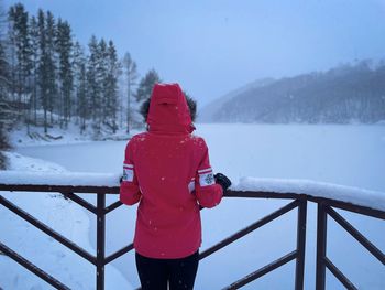 Rear view of man standing on snow covered landscape