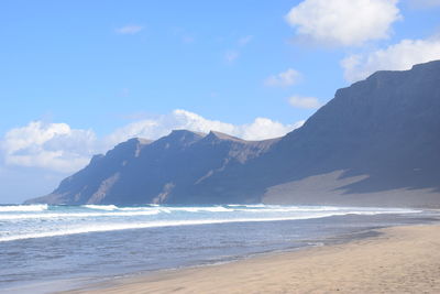 Scenic view of sea and mountains against sky