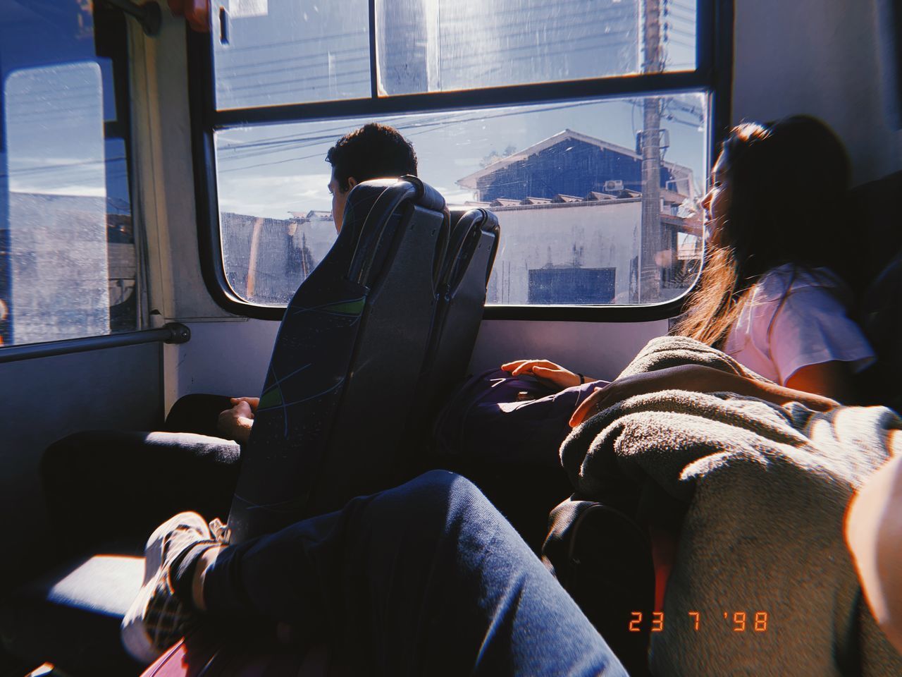 REAR VIEW OF PEOPLE SITTING ON TRAIN WINDOW