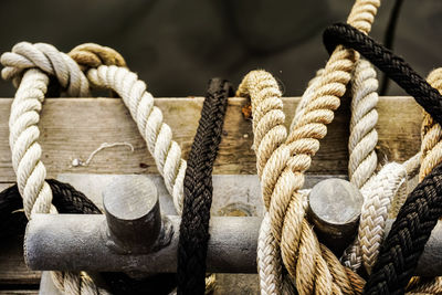 Close-up of ropes tied on wooden boat on river