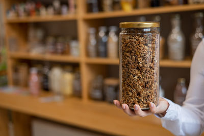 Close-up of hand holding glass jar