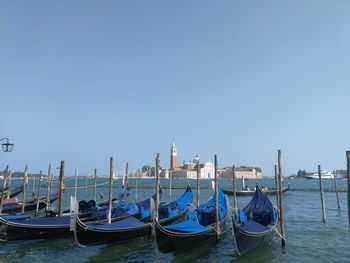Boats moored in canal against clear sky